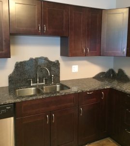 Brown cabinets with granite countertops.